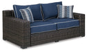 Grasson Lane Grasson Lane Nuvella Loveseat with Fire Pit Table Outdoor Table Set Ashley Furniture